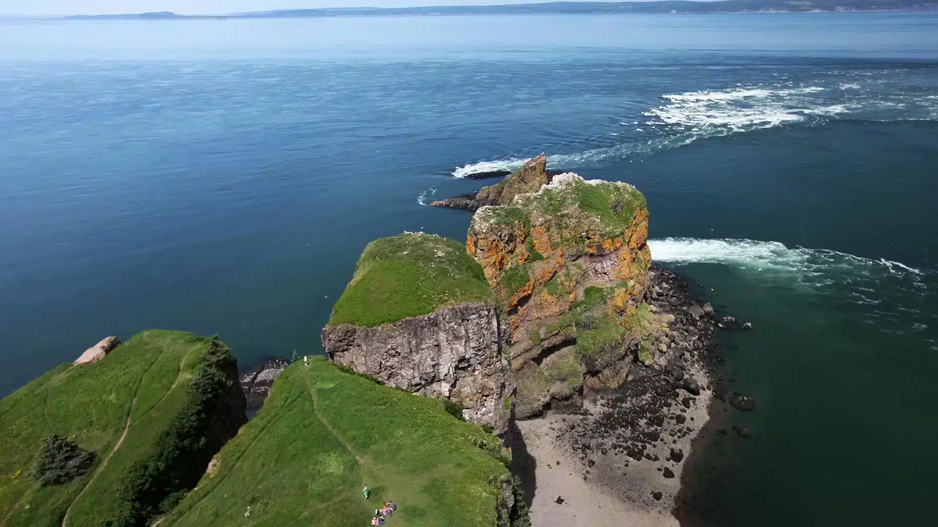 Hikers at the top of the Cape Split Provincial Park Reserve hiking trail which overlooks the Bay of Fundy in Nova Scotia.