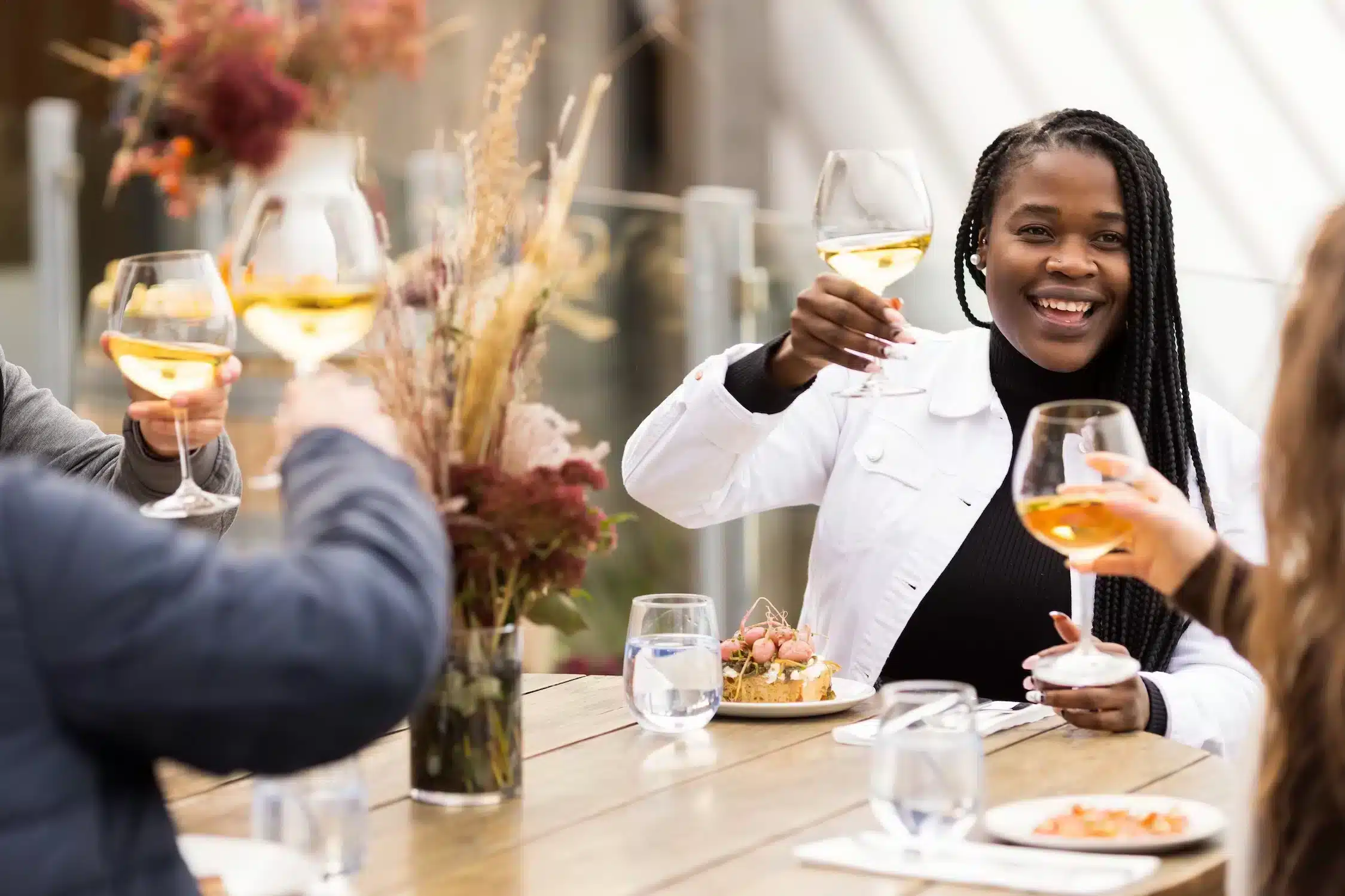 woman sitting at a table with friends drinking wine